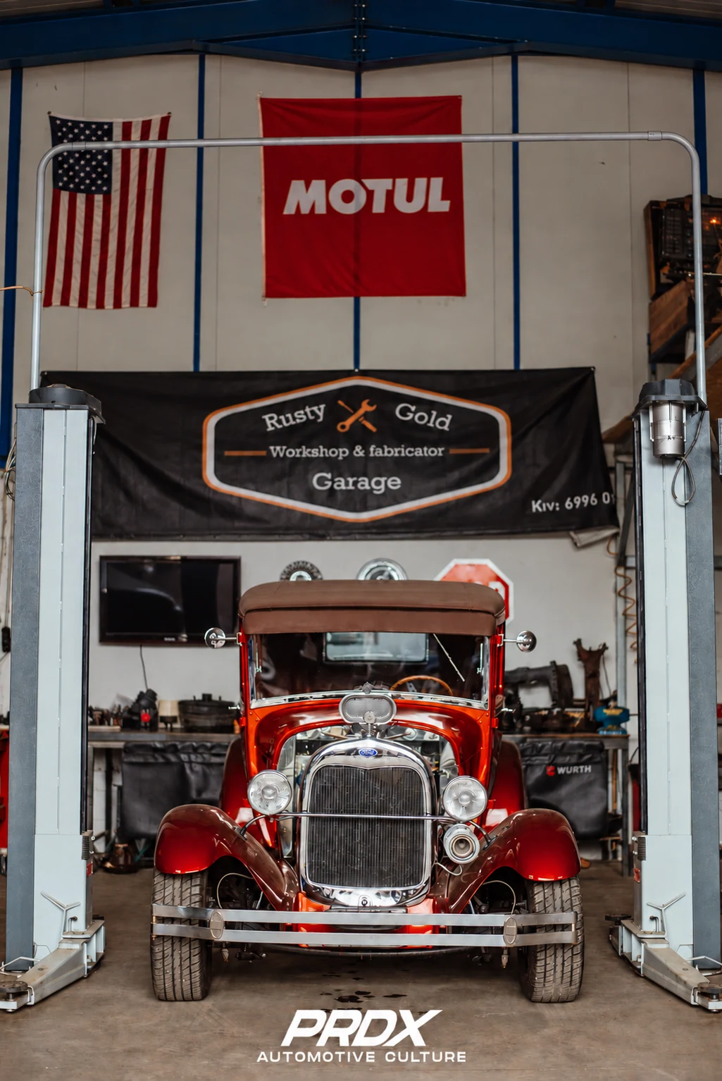Vintage Ford hot rod between workshop lifts